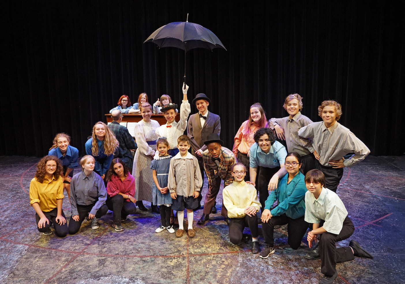 the cast of Mary Poppins -under Mary's umberlla, plus musical director Tim Guiles